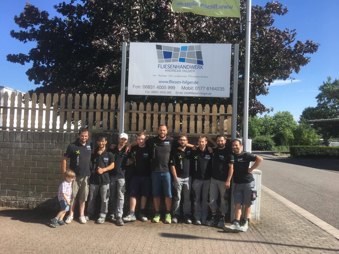 Das Team vor dem Firmenschild
